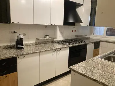 a kitchen with white cabinets and a stove top oven at FAIROME Apartment 2 Pini in Rome
