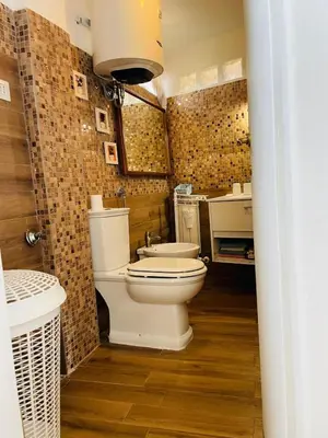 a kitchen with a stainless steel refrigerator and white cabinets at Terrazza Gianicolense in Rome