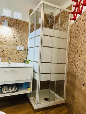 a glass shower in a bathroom with a sink at Terrazza Gianicolense in Rome