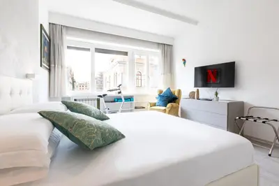 a white bedroom with two beds and a window at Comfortable Dream Apartment Piazza del Popolo in Rome