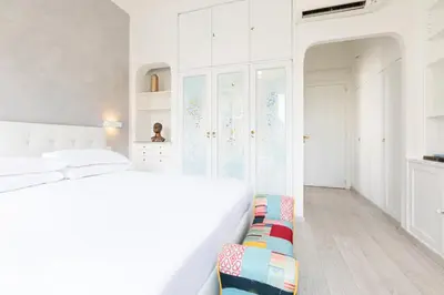 a white bedroom with a white bed and a couch at Comfortable Dream Apartment Piazza del Popolo in Rome