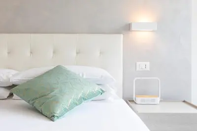 a bedroom with a white bed with a blue pillow at Comfortable Dream Apartment Piazza del Popolo in Rome