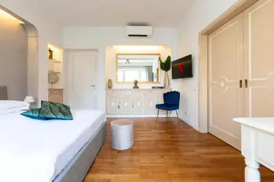 a bedroom with two beds and a blue chair at Comfortable Dream Apartment Piazza del Popolo in Rome