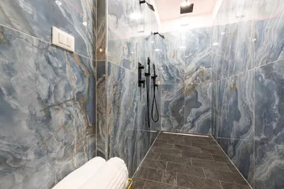 a bathroom with a shower with a stone wall at Comfortable Dream Apartment Piazza del Popolo in Rome