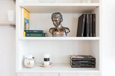 a book shelf with a statue of a woman at Comfortable Dream Apartment Piazza del Popolo in Rome
