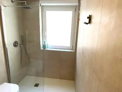 a bathroom with a shower with a window and a toilet at Olmocolmo Trastevere in Rome
