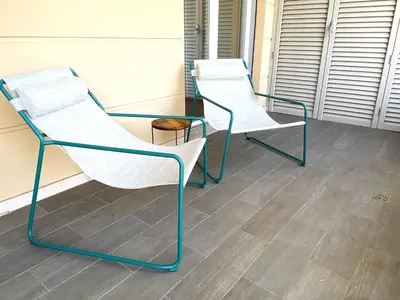 two white chairs and a glass table on a porch at Olmocolmo Trastevere in Rome