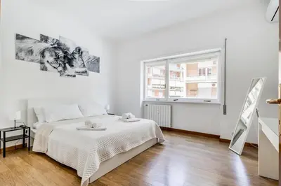 a white bedroom with a bed and a window at Tiburtina White House in Rome