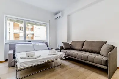 a living room with a couch and a bed at Tiburtina White House in Rome