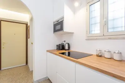 a white kitchen with a sink and a microwave at Oscar Apt near Landmarks and Colosseum in Rome