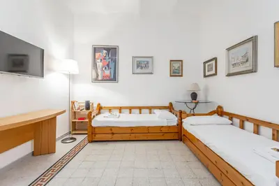 a room with three beds and a tv on the wall at Oscar Apt near Landmarks and Colosseum in Rome