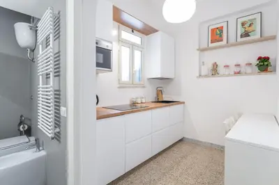 a white kitchen with a sink and a window at Oscar Apt near Landmarks and Colosseum in Rome