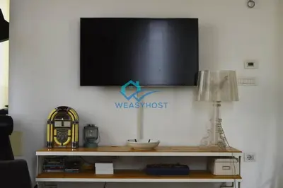 a tv on a wall with a table with a lamp at Cozy Design Flat - Trastevere in Rome