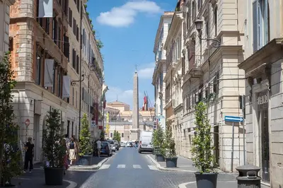 a city street with buildings and potted plants on the sidewalk at Amazing Via del Babuino - Piazza del Popolo in Rome