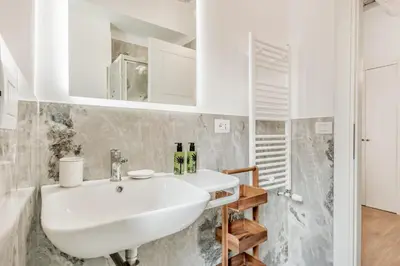 a kitchen with white cabinets and a sink at APT ROME - Vittoria Palace in Rome