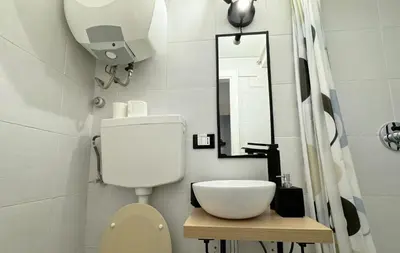 a bathroom with a toilet and a sink and a mirror at SorinaHome Vatican Studio in Rome