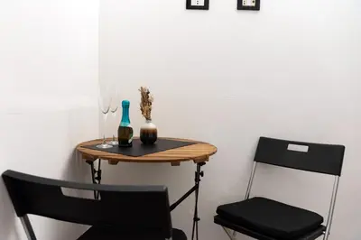 a small table with two chairs and a bottle and a vase at SorinaHome Vatican Studio in Rome