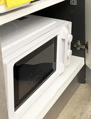 a microwave oven on a shelf in a kitchen at SorinaHome Vatican Studio in Rome