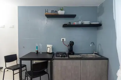 a kitchen with a sink and a counter with chairs at SorinaHome Vatican Studio in Rome