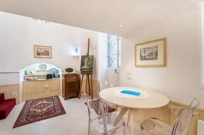 a living room with a table and a kitchen at Studio d'Artista, Elegante Loft nel Cuore di Roma in Rome
