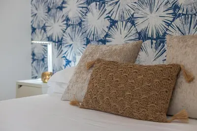a bed with two pillows and a blue and white wallpaper at Minerva - Elegant New Classic close to Vatican in Rome