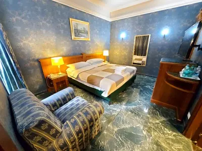a bedroom with a bed and a couch and a chair at Hotel Positano 2 in Rome