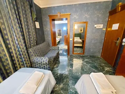 a room with two beds and a couch and a mirror at Hotel Positano 2 in Rome