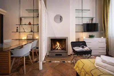 a glass table in a room with chairs and a kitchen at Vittoria House in Rome