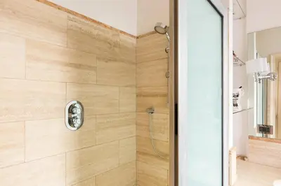 a bathroom with a shower with a glass door at Holiday Room Naiadis in Rome