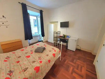 a bedroom with a bed and a television in it at Holiday Room Naiadis in Rome