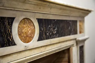 a close up of a wooden fireplace with gold detailing at Corso Grand Suite in Rome