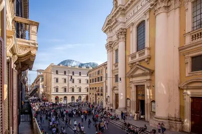 a crowd of people walking down a street between buildings at Corso Grand Suite in Rome