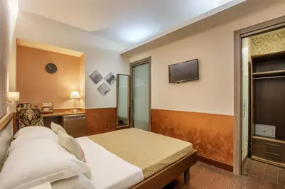 a bedroom with a bed and a tv on the wall at Corso Grand Suite in Rome