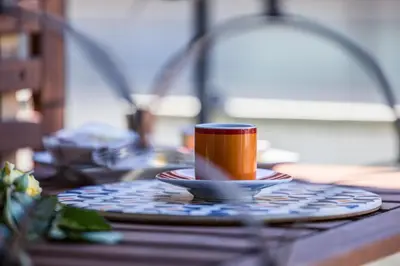 a coffee cup sitting on a plate on a table at MHouse Roma in Rome
