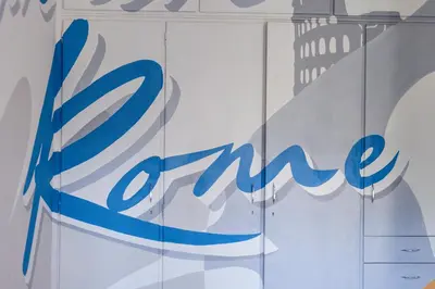 a blue sign on the side of a store window at MHouse Roma in Rome