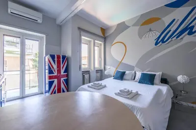 a bedroom with a large white bed and a table at MHouse Roma in Rome