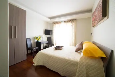 a bedroom with a bed and a desk and a window at Di Fronte alla Cupola in Rome