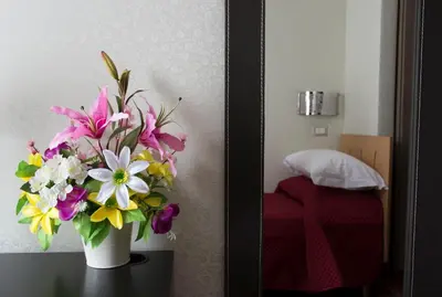 a vase of flowers on a table in a room at Di Fronte alla Cupola in Rome