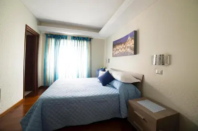 a bedroom with a bed with blue sheets and a window at Di Fronte alla Cupola in Rome