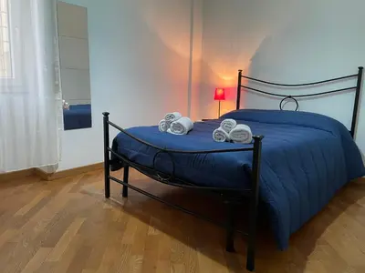 a bed with a blue comforter and two towels at Ammiragli Vatican Experience in Rome