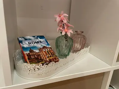 a shelf with a vase and a book and a flower at Ammiragli Vatican Experience in Rome