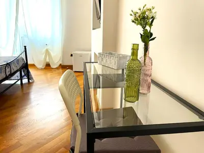 a glass table with a bottle and a vase with flowers at Ammiragli Vatican Experience in Rome