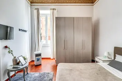 a bedroom with a bed and a tv and a chair at Corso Trieste 62 in Rome