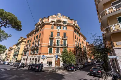 a tall orange building with cars parked in front of it at Corso Trieste 62 in Rome