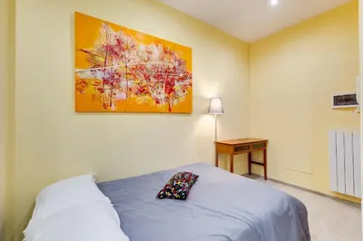 a bedroom with a bed and a painting on the wall at Monteverde Cozy Apartment in Rome
