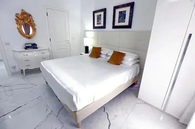 a bedroom with a bed with white sheets and orange pillows at DOLCE VITA VIMINALE ROOM in Rome