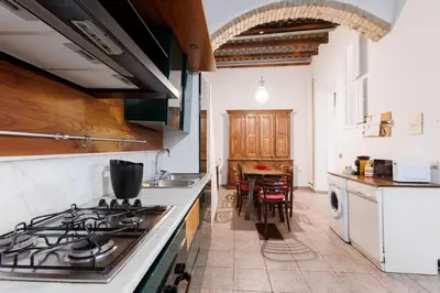 a kitchen with a stove top oven next to a table at Navona Glamour Apartment in Rome