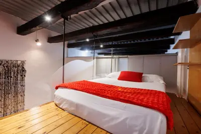 a bedroom with a large white bed with a red blanket at Navona Glamour Apartment in Rome
