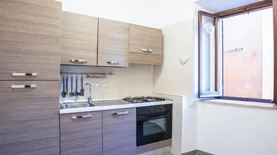 a kitchen with wooden cabinets and a sink and a window at EasyTopStay - Piazza Navona Elegant Apartment in Rome