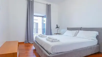 a white bed in a room with a large window at EasyTopStay - Piazza Navona Elegant Apartment in Rome